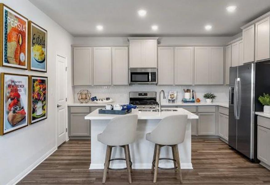 Kitchen featuring a sink, light countertops, appliances with stainless steel finishes, dark wood finished floors, and gray cabinets Kitchen featuring a sink, light countertops, appliances with stainless steel finishes, dark wood finished floors, and gray cabinets