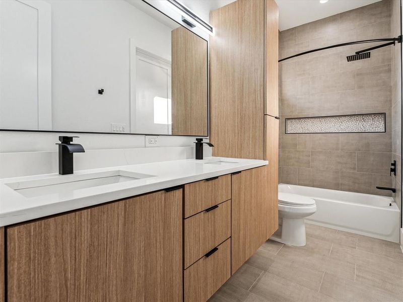 Full bathroom featuring tiled shower / bath, vanity, toilet, and tile patterned floors