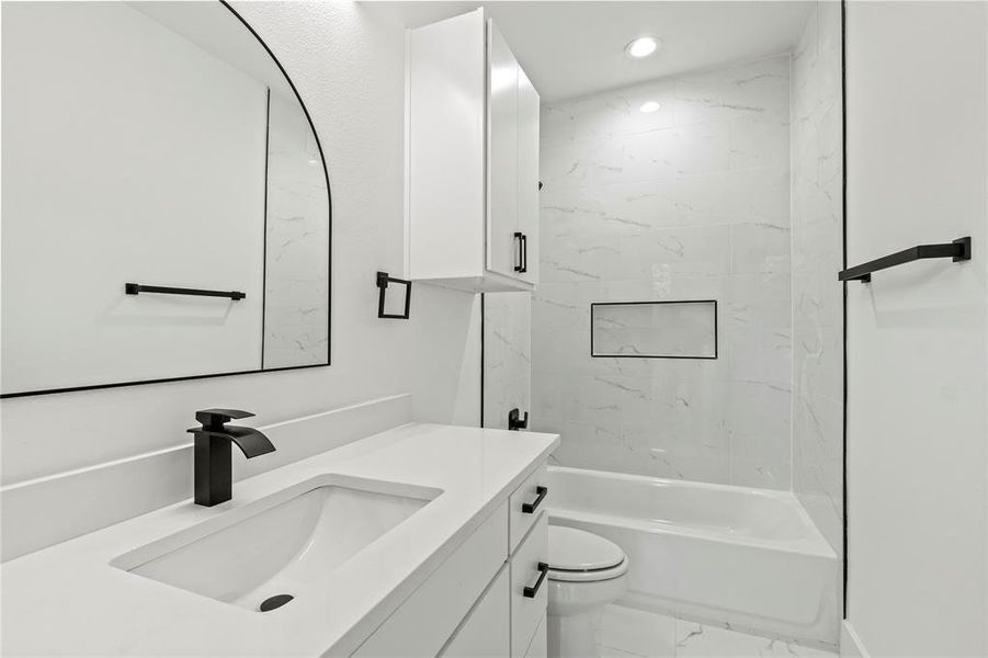 Bathroom with marble finish flooring, toilet, vanity, recessed lighting, and shower combination Bathroom with marble finish flooring, toilet, vanity, recessed lighting, and shower combination