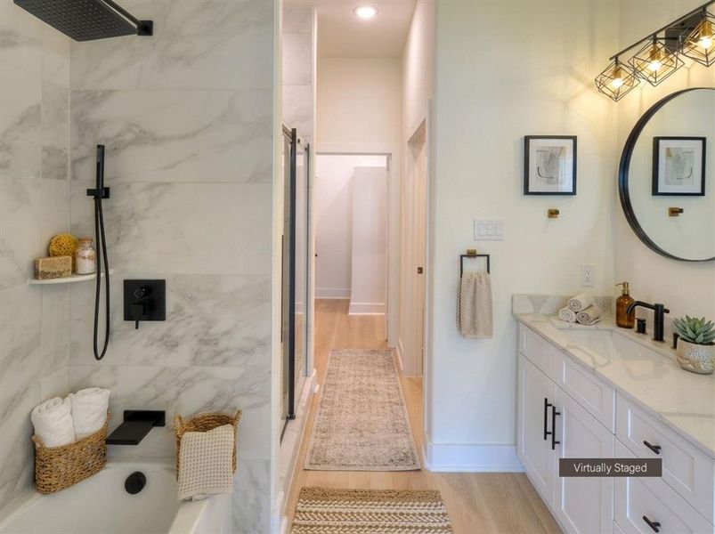 Bathroom featuring a white vanity with black hardware, a round framed mirror, and a three-light vanity fixture