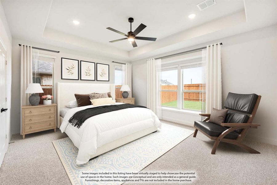 Master bedroom with tray ceiling, ceiling fan, carpet flooring, and large windows overlooking backyard Master bedroom with tray ceiling, ceiling fan, carpet flooring, and large windows overlooking backyard