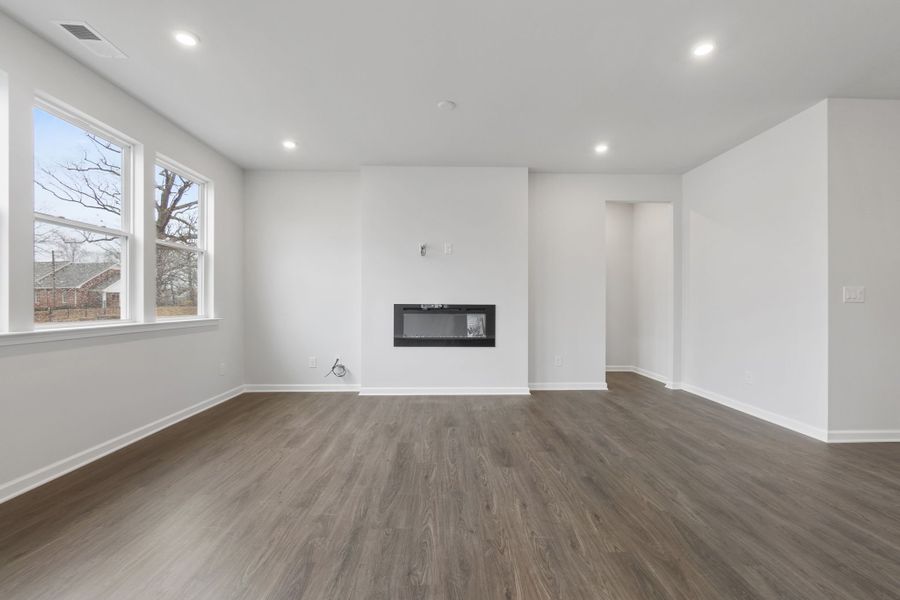 A room with a wood floor and a wood floor with a window.
