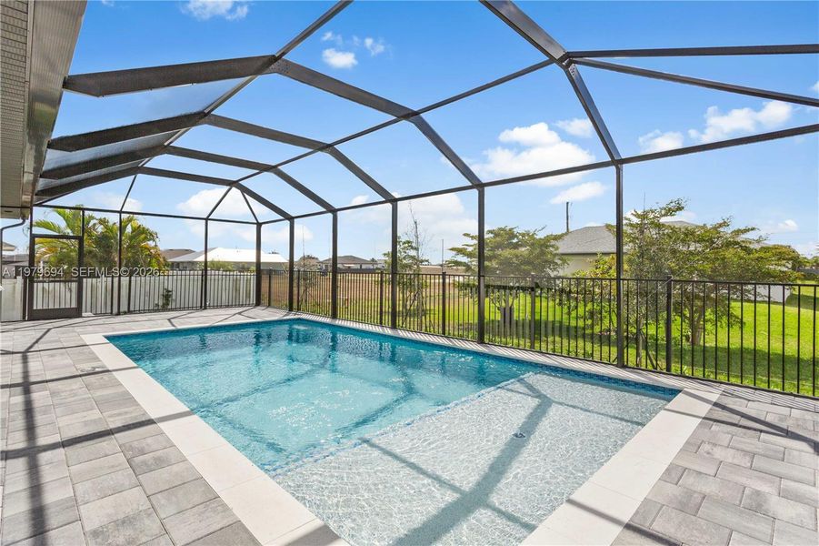 Step outside to SCREENED LANAI w/ SALTWATER POOL, landscaped surrounding & FULLY EQUIPED OUTDOOR KITCHEN w/ BUILT-IN stainless steel BBQ GRILL, SINK, BEVERAGE REFRIGERATOR, GRANITE COUNTERTOPS & MODERN BACKSPLASH, ideal for OUTDOOR DINING & ENTERTAINING Step outside to SCREENED LANAI w/ SALTWATER POOL, landscaped surrounding & FULLY EQUIPED OUTDOOR KITCHEN w/ BUILT-IN stainless steel BBQ GRILL, SINK, BEVERAGE REFRIGERATOR, GRANITE COUNTERTOPS & MODERN BACKSPLASH, ideal for OUTDOOR DINING & ENTERTAINING