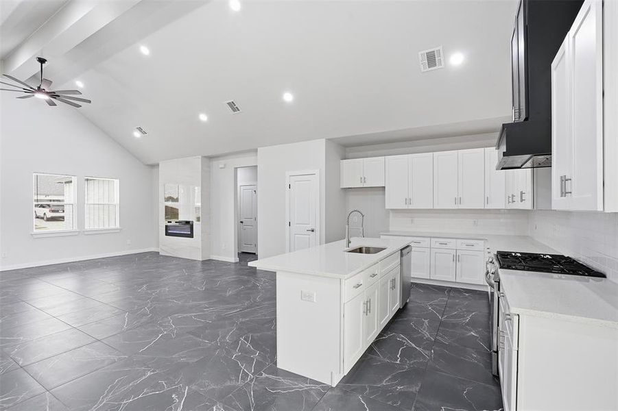 Open-concept living space with vaulted ceilings and recessed lighting