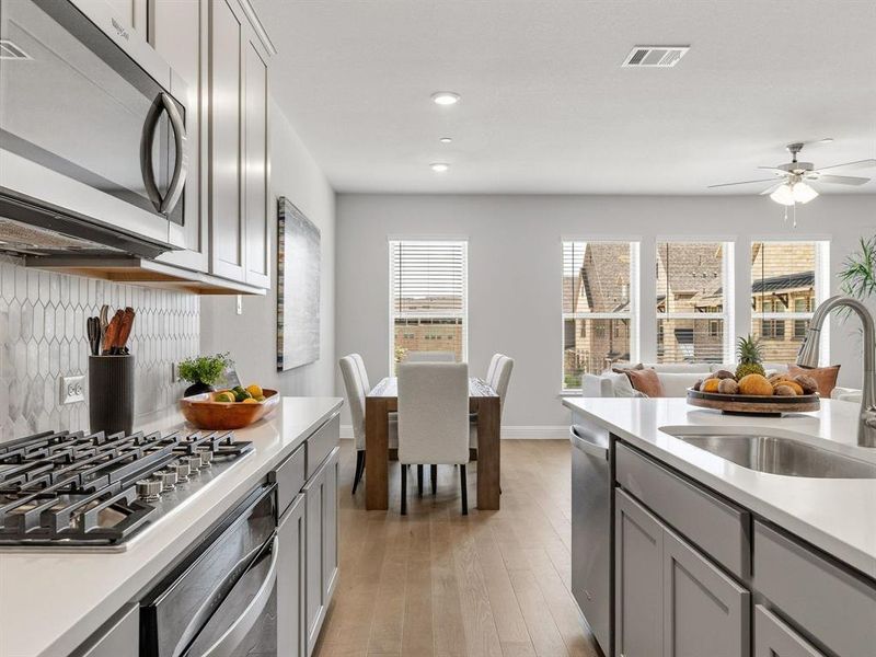 Premium cooking features include a high-end 5-burner gas cooktop, separate built-in oven, and a professional-grade exterior vented hood.