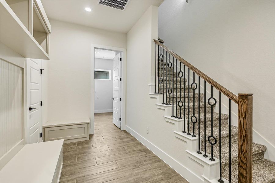 Stairway with wood finished floors and recessed lighting