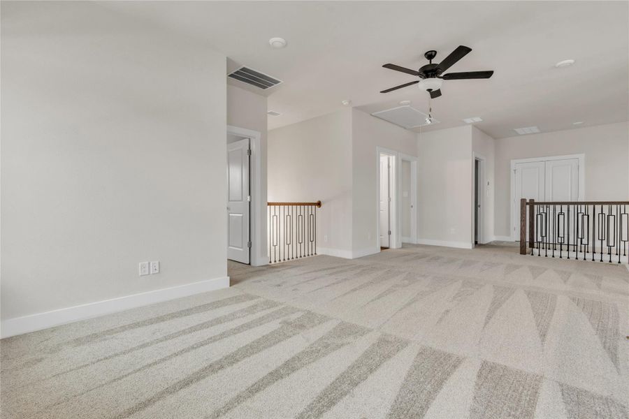 A spacious upper-level bonus room awaits with plush carpet and a convenient ceiling fan.
