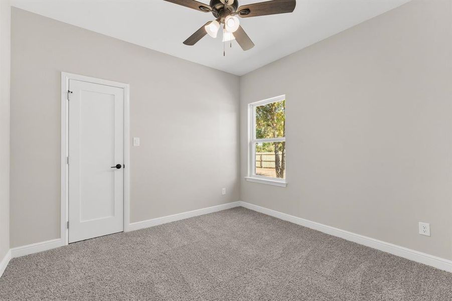 Empty room with carpet flooring and a ceiling fan