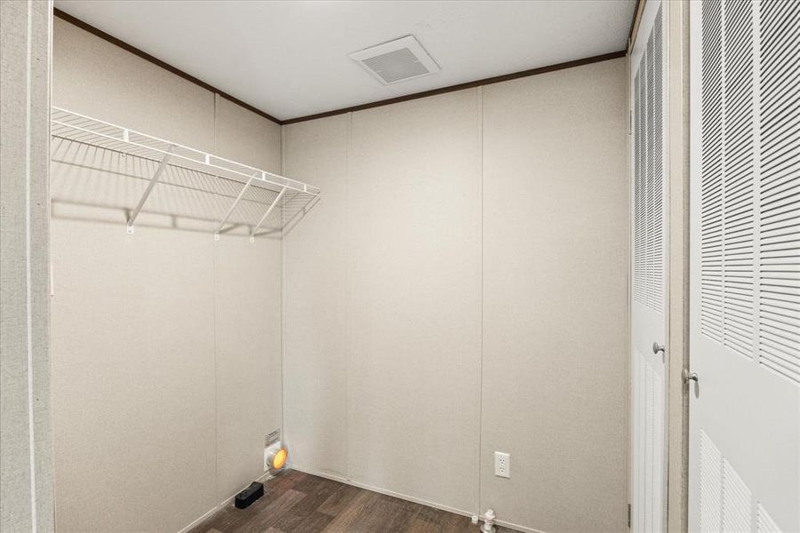 Utility space with wood-finish flooring and white paneled walls