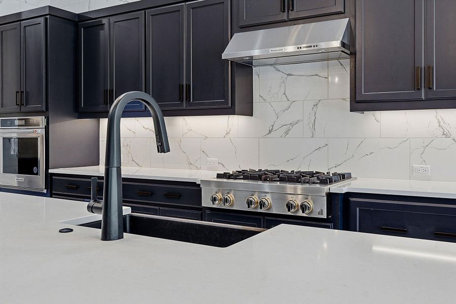 A refined kitchen showcasing sleek cabinetry and a sophisticated gas range with modern amenities. A refined kitchen showcasing sleek cabinetry and a sophisticated gas range with modern amenities.