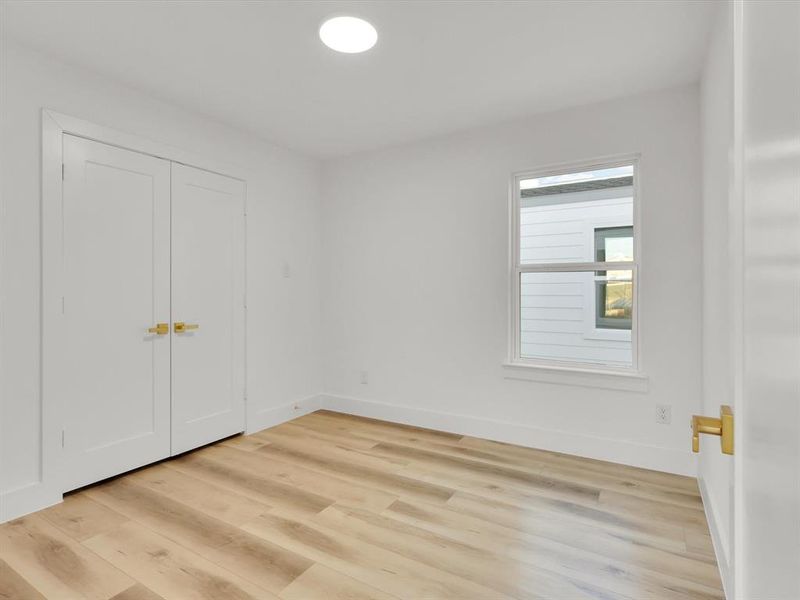 Unfurnished bedroom featuring light wood-type flooring and a closet