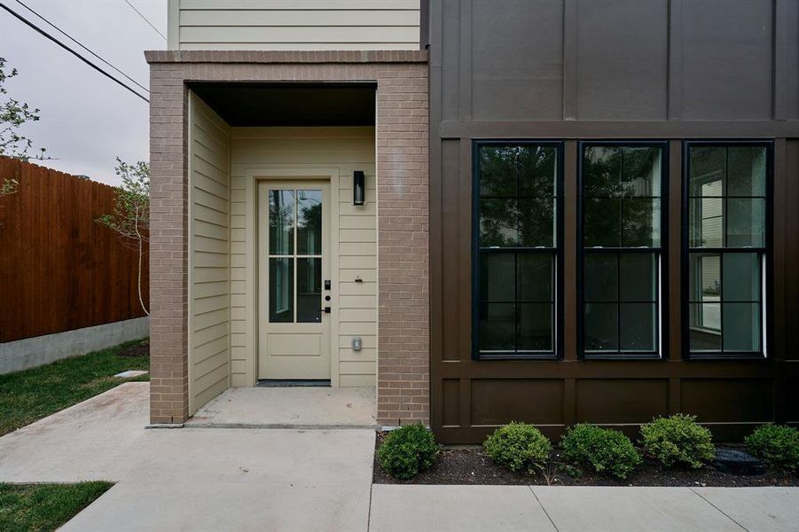 Modern facade with a neutral-toned entry door and black-framed windows