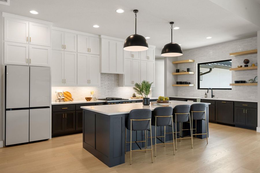 Elegant hardwood flooring anchors a kitchen showcasing dual-tone cabinetry and stone countertops.