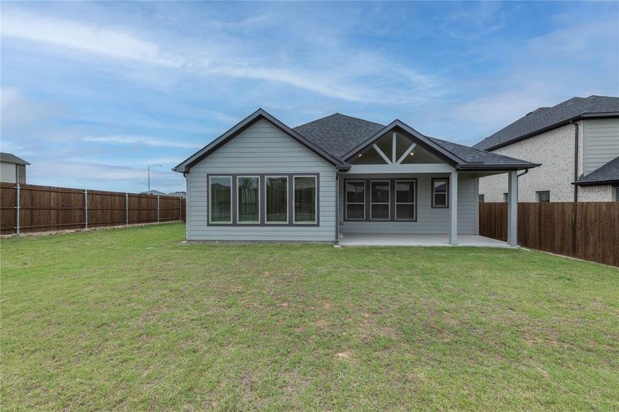Rear view of property featuring a patio area and a shingled roof