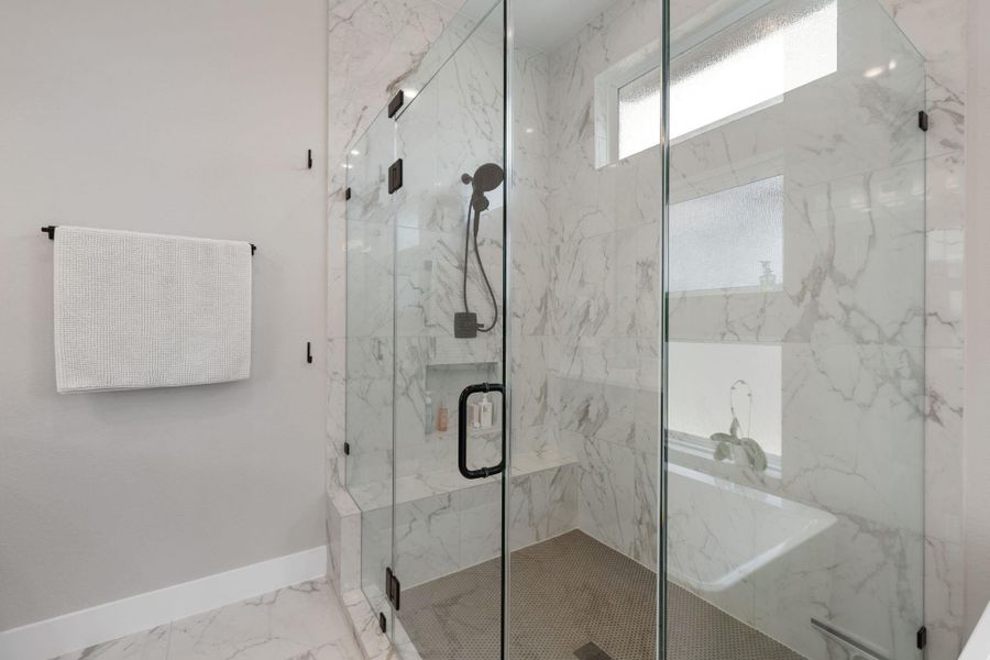 The shower is spacious, with modern fixtures and a frameless glass enclosure. Natural light pours in through the windows, highlighting the elegant finishes. The shower is spacious, with modern fixtures and a frameless glass enclosure. Natural light pours in through the windows, highlighting the elegant finishes.