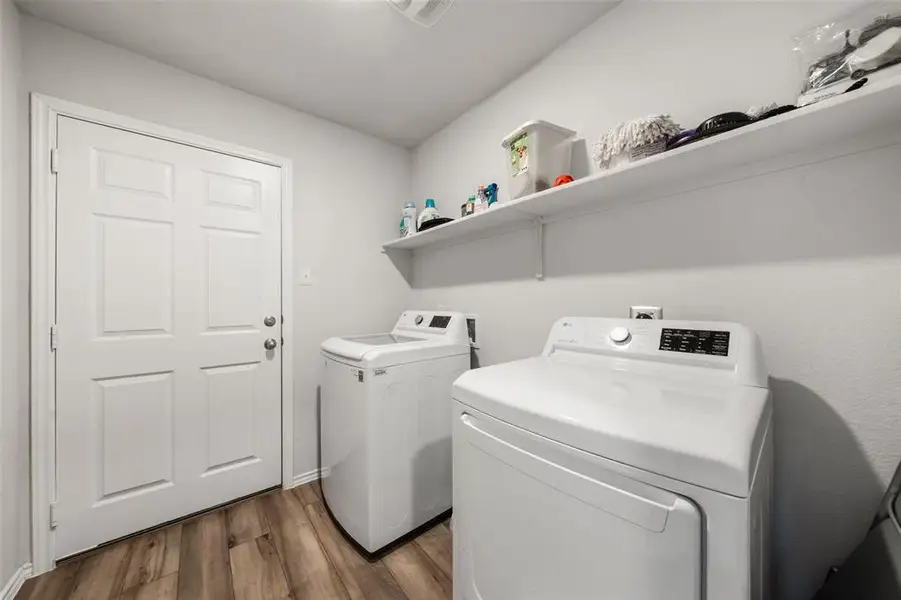 Washroom featuring dark wood-type flooring and independent washer and dryer