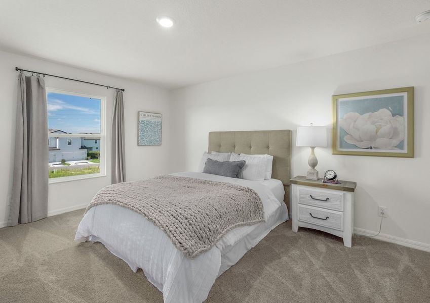 A large picture window lets in plenty of light to this master bedroom.