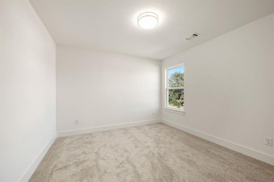 Unfurnished room featuring light carpet and baseboards