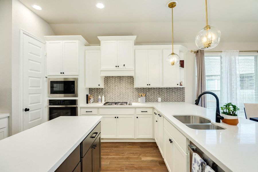 Quartz countertops, double sink, gas range, pantry, and ample workspace for the family chef. Quartz countertops, double sink, gas range, pantry, and ample workspace for the family chef.