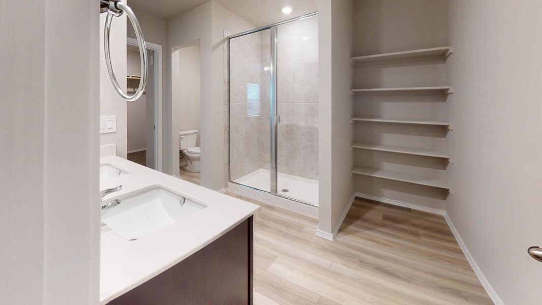 A well-appointed primary bathroom showcases dual vanity sinks, a sleek shower, and ample storage. A well-appointed primary bathroom showcases dual vanity sinks, a sleek shower, and ample storage.