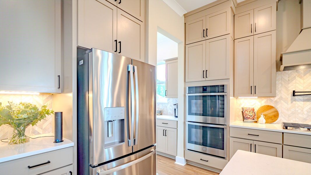Kitchen with tile backsplash, quartz countertops, and stainless-steel appliances Kitchen with tile backsplash, quartz countertops, and stainless-steel appliances