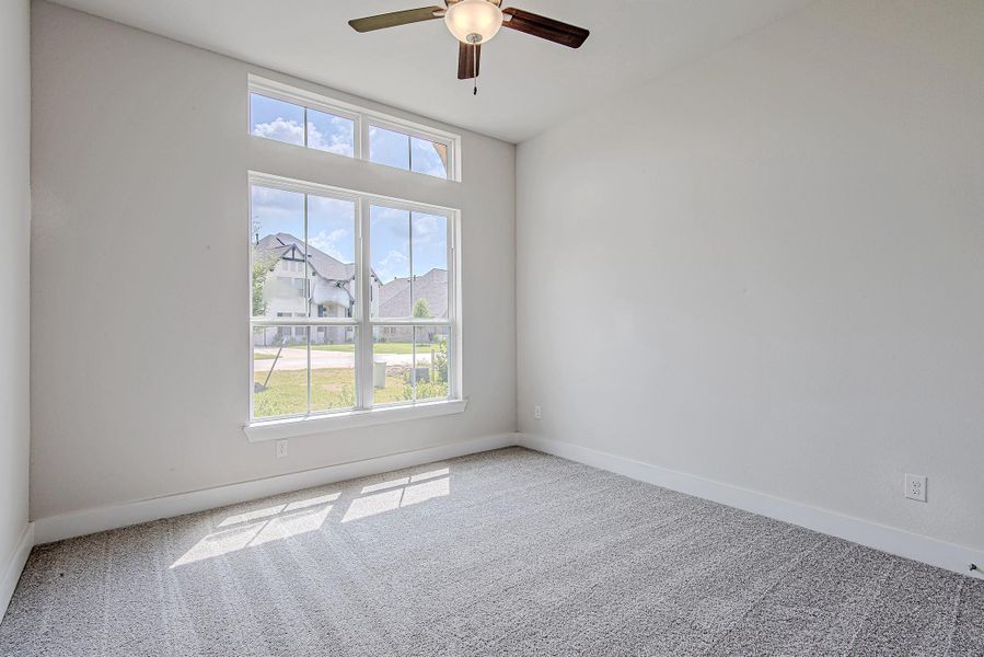 Comfortable secondary bedroom with large window and ceiling fan. Comfortable secondary bedroom with large window and ceiling fan.