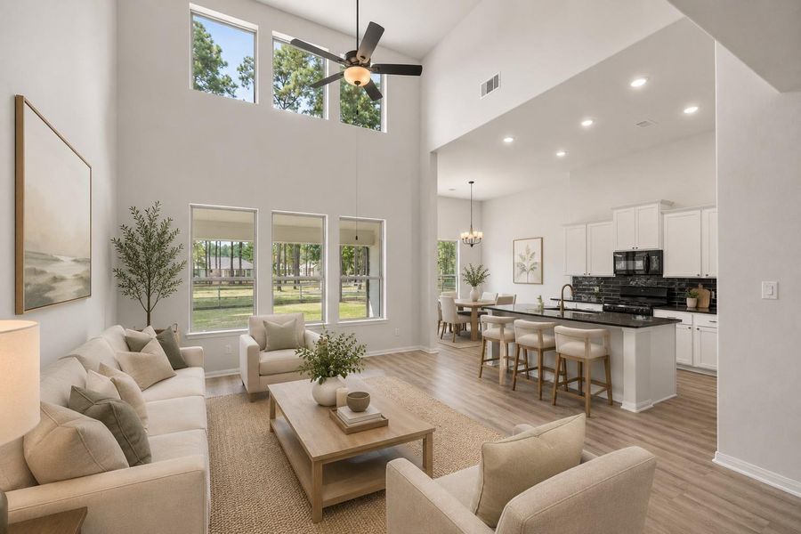 Spacious open-concept living area with soaring ceilings and abundant natural light, seamlessly connecting to a modern kitchen. *Virtually staged