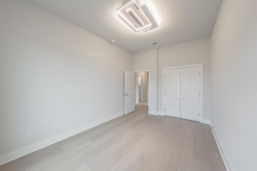 Unfurnished bedroom featuring light wood-type flooring and a closet