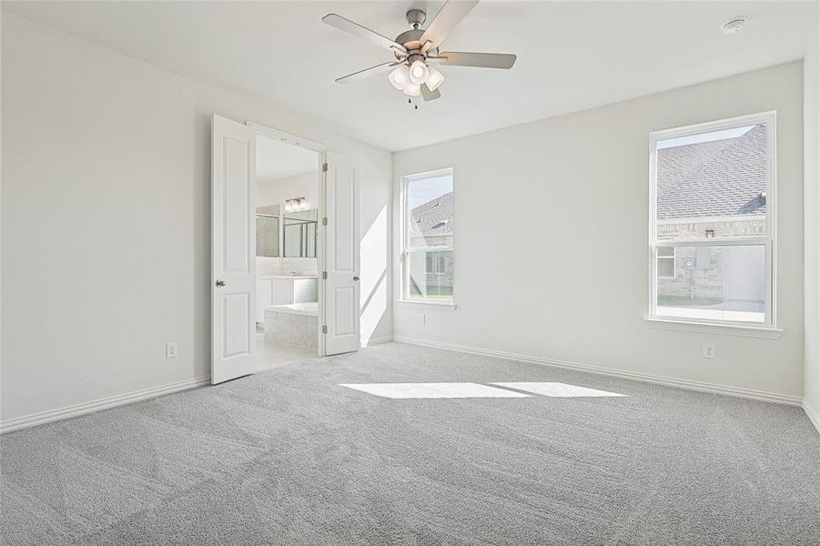 Carpeted empty room featuring ceiling fan