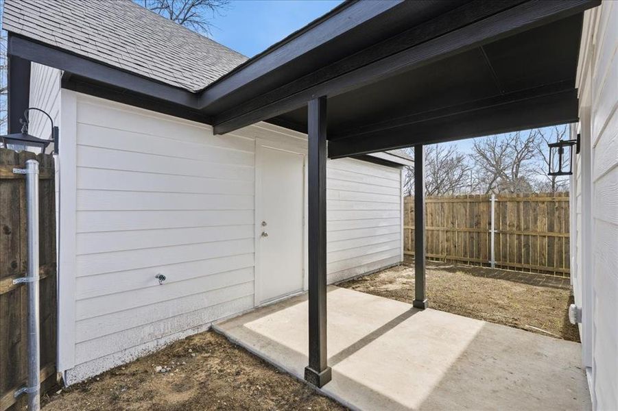 Covered walkway leading to the detached garage, offering convenient access and added protection from the elements.