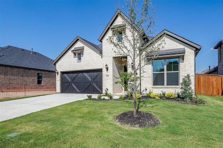 View of front of house with a garage and a front yard