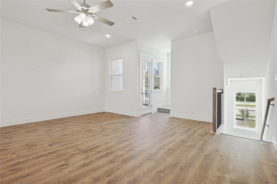 Unfurnished living room with ceiling fan and light hardwood / wood-style floors