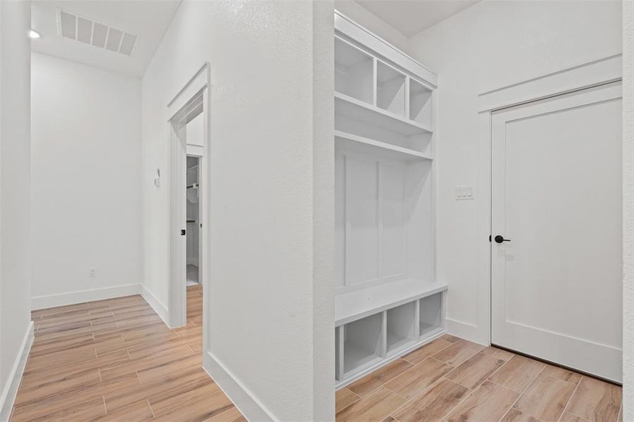 Mudroom featuring wood tiled floors and baseboards