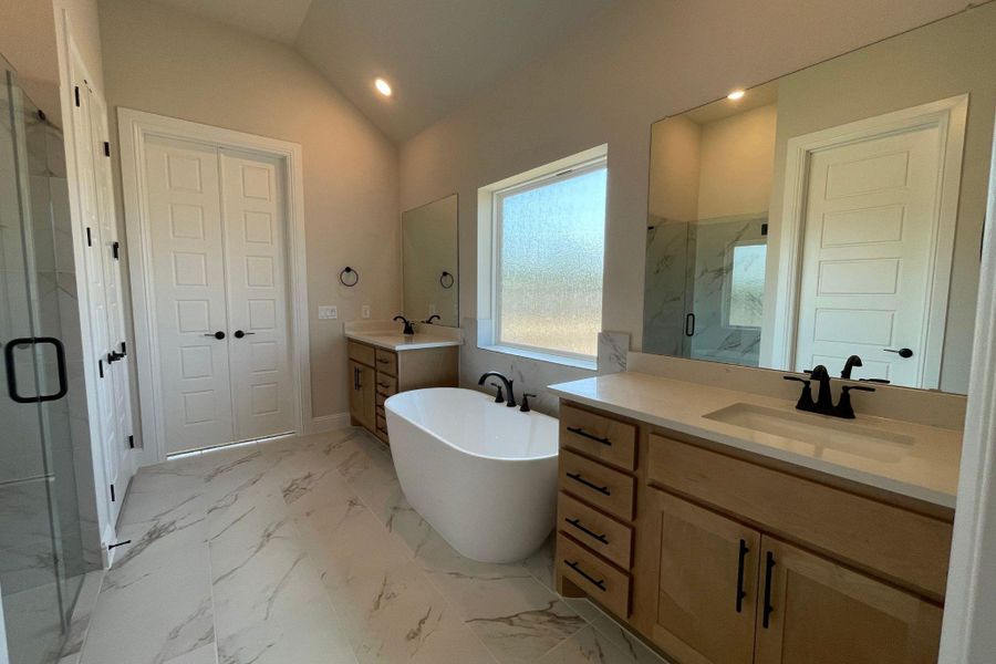 Marble-patterned tile flooring and a freestanding tub highlight this modern, high-ceilinged washroom. Marble-patterned tile flooring and a freestanding tub highlight this modern, high-ceilinged washroom.