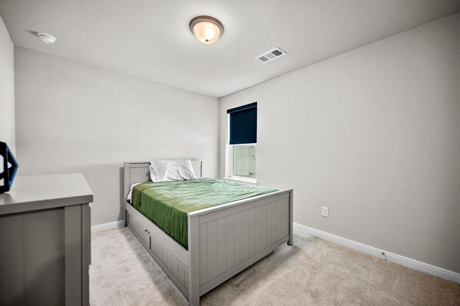 Bedroom featuring light colored carpet and a textured ceiling Bedroom featuring light colored carpet and a textured ceiling