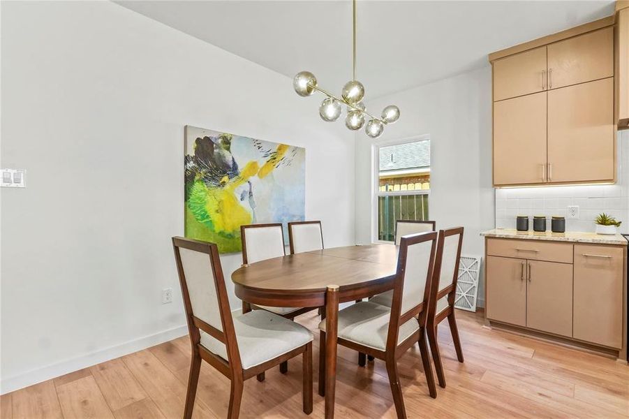 Dining area with light wood-style floors and a chandelier Dining area with light wood-style floors and a chandelier