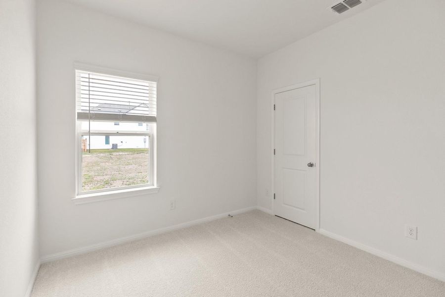 Empty room with light colored carpet and baseboards
