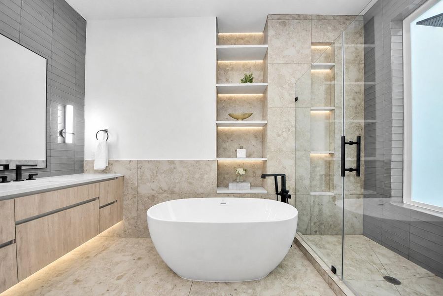 Primary bathroom featuring a freestanding tub, glass-enclosed shower, and built-in shelving.