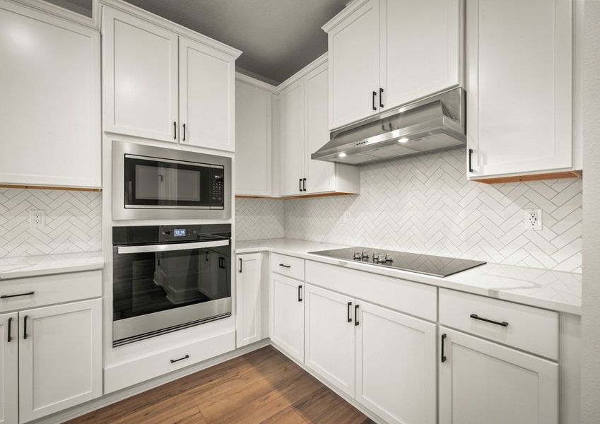 Kitchen with white cabinets and quartz countrtops.