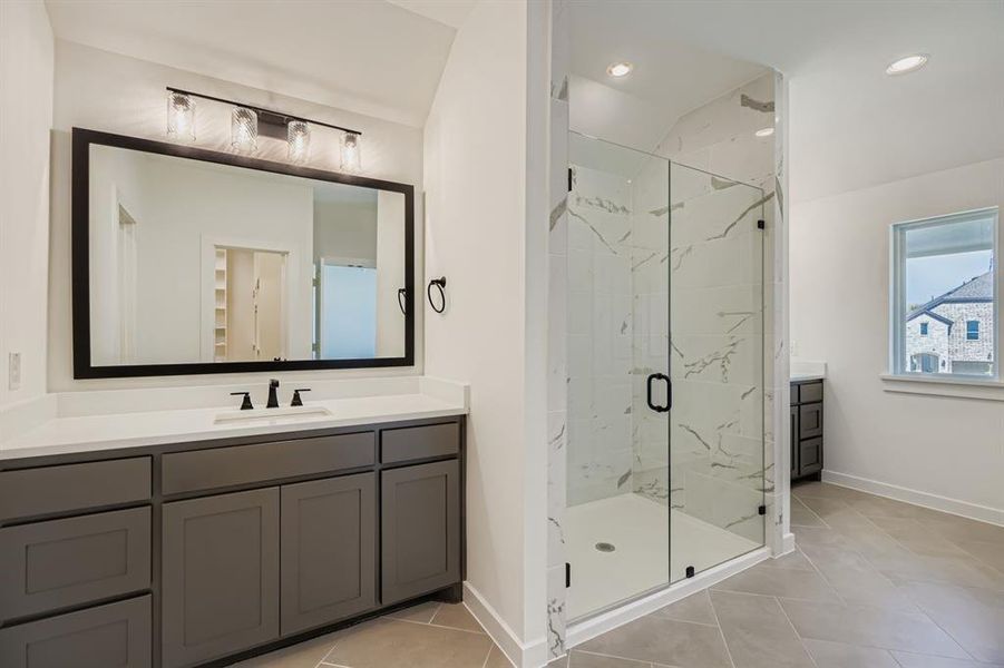 Full bathroom with vanity, a marble finish shower, light tile patterned floors, and recessed lighting
