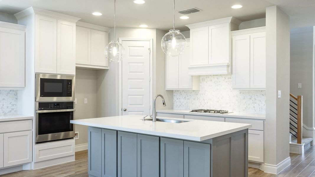 Kitchen featuring light countertops, visible vents, stainless steel appliances, a sink, and light wood-type flooring Kitchen featuring light countertops, visible vents, stainless steel appliances, a sink, and light wood-type flooring