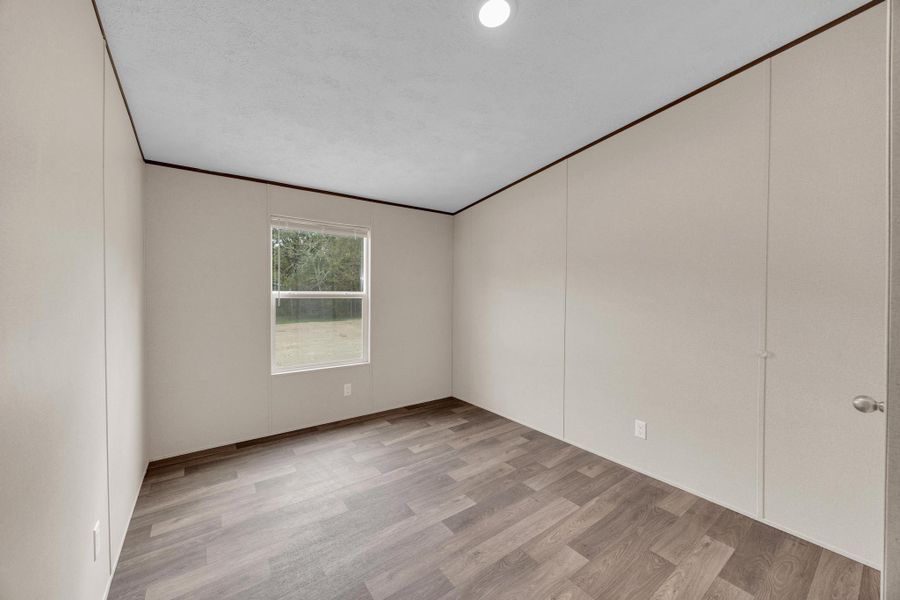 Unfurnished room with light wood-style flooring and ornamental molding