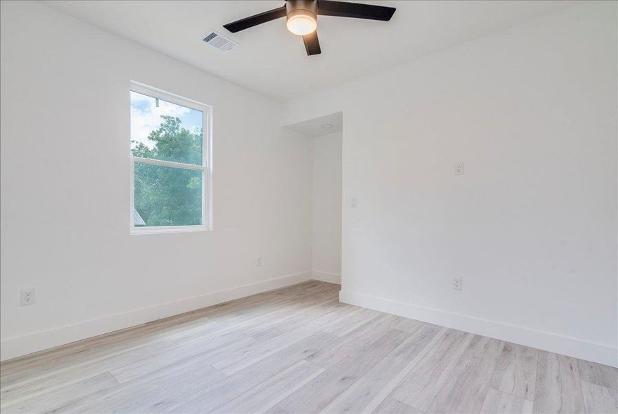 Empty room with light wood-style flooring and ceiling fan Empty room with light wood-style flooring and ceiling fan