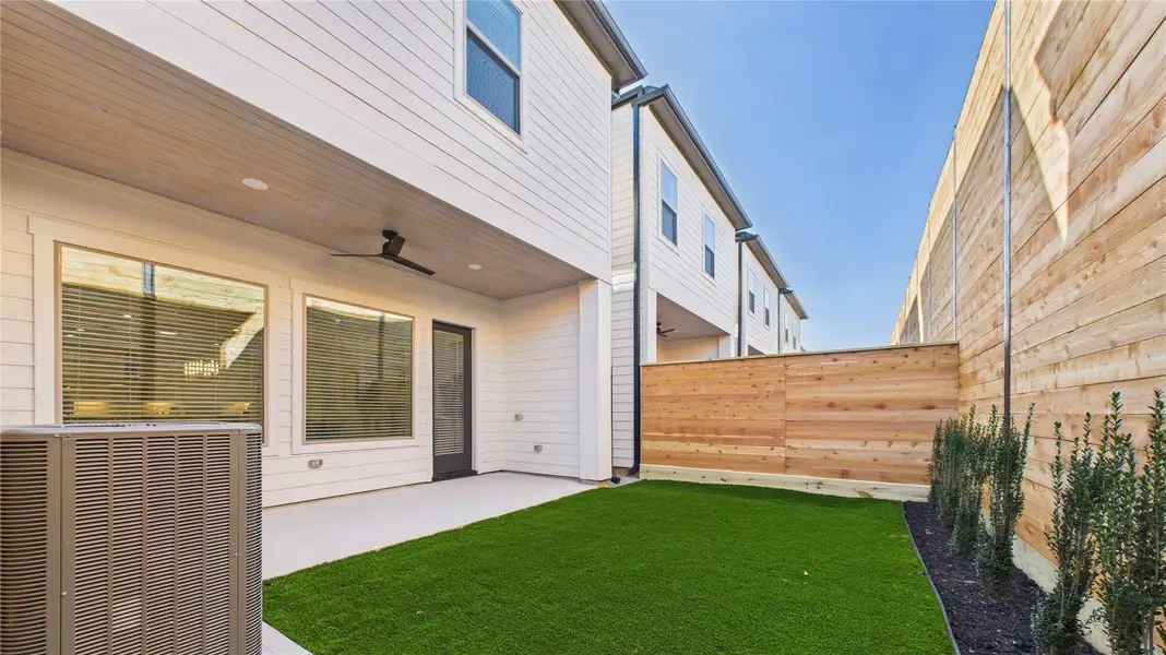 Backyard has plenty of room for entertainment with grass**Photo of model home with upgrade: artificial grass, flower bed**