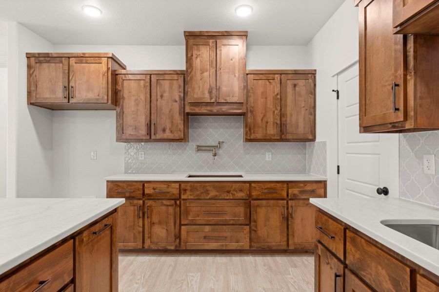 Custom cabinetry and immaculate countertops define this newly appointed culinary space.