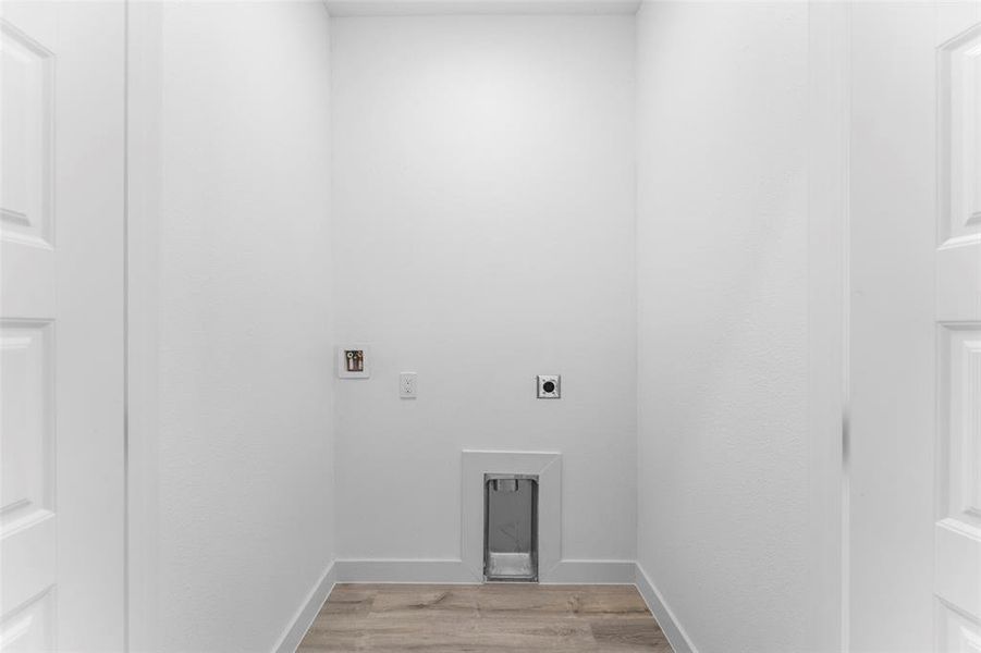 Washroom with light wood-type flooring, hookup for an electric dryer, and washer hookup