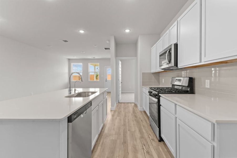 A kitchen with white cabinets.