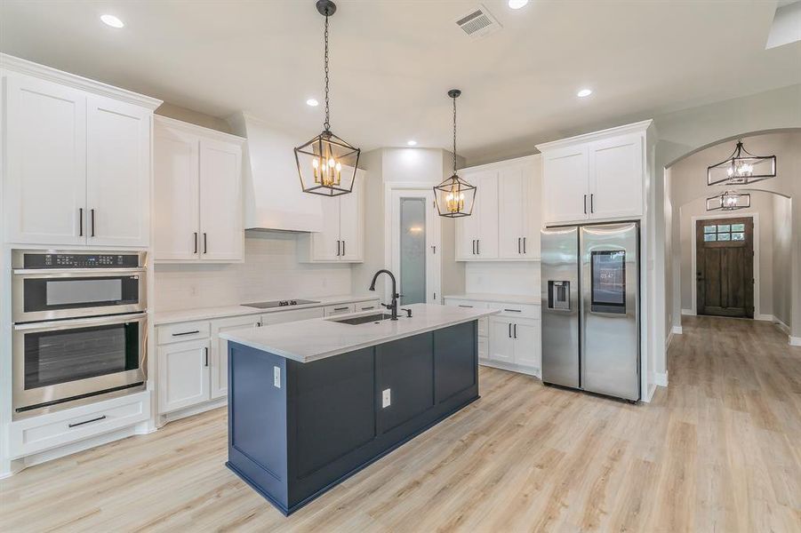 Kitchen featuring appliances with stainless steel finishes, a sink, decorative backsplash, light wood-style floors, and recessed lighting Kitchen featuring appliances with stainless steel finishes, a sink, decorative backsplash, light wood-style floors, and recessed lighting