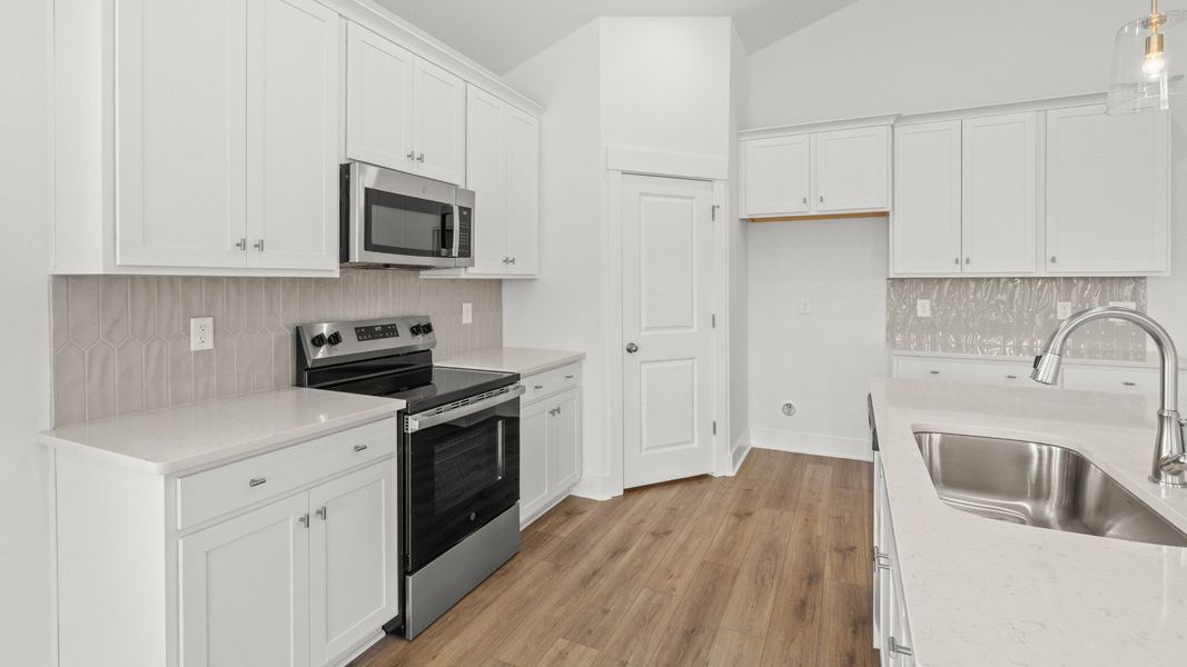 Stylish kitchen with white cabinets, quartz countertops, and stainless steel appliances at 144 Joyce Drive Stylish kitchen with white cabinets, quartz countertops, and stainless steel appliances at 144 Joyce Drive