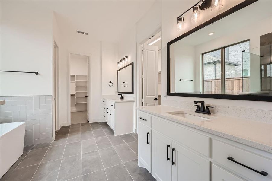 Bathroom featuring tile walls, vanity, a tub, and tile patterned flooring